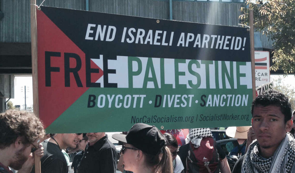 Manifestatie voor Palestina en BDS tegen Israel in Frankrijk. Met bord in de kleuren van de Palestijnse vlag dat zegt "End Israeli Apartheid. Free Palestine. Boycott. Divest. Sanction"