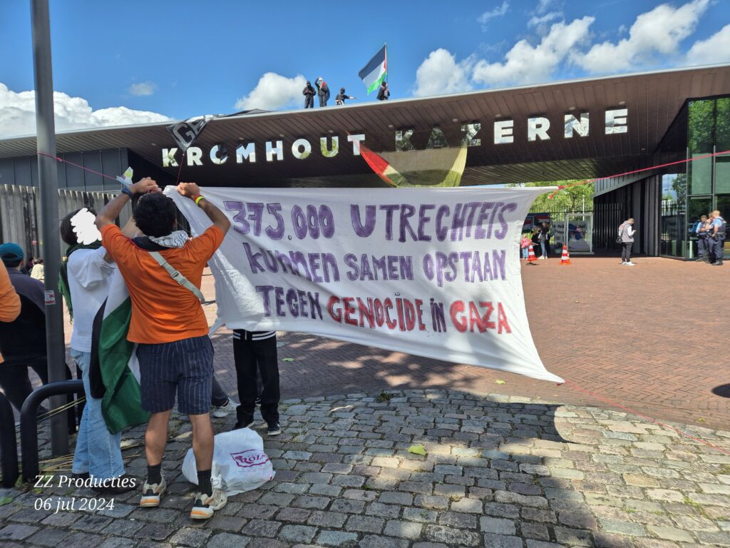 Spandoek bij de Kromhoutkazerne met de tekst "375.000 Utrechters kunnen samen opstaan tegen genocide in Gaza"